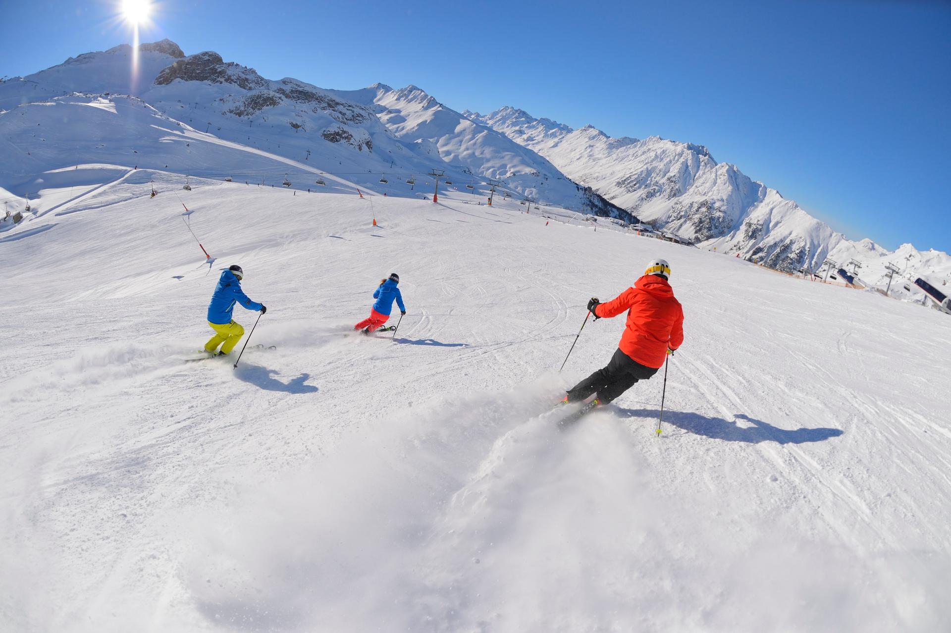 3 skiiers skiing down piste at ischgl