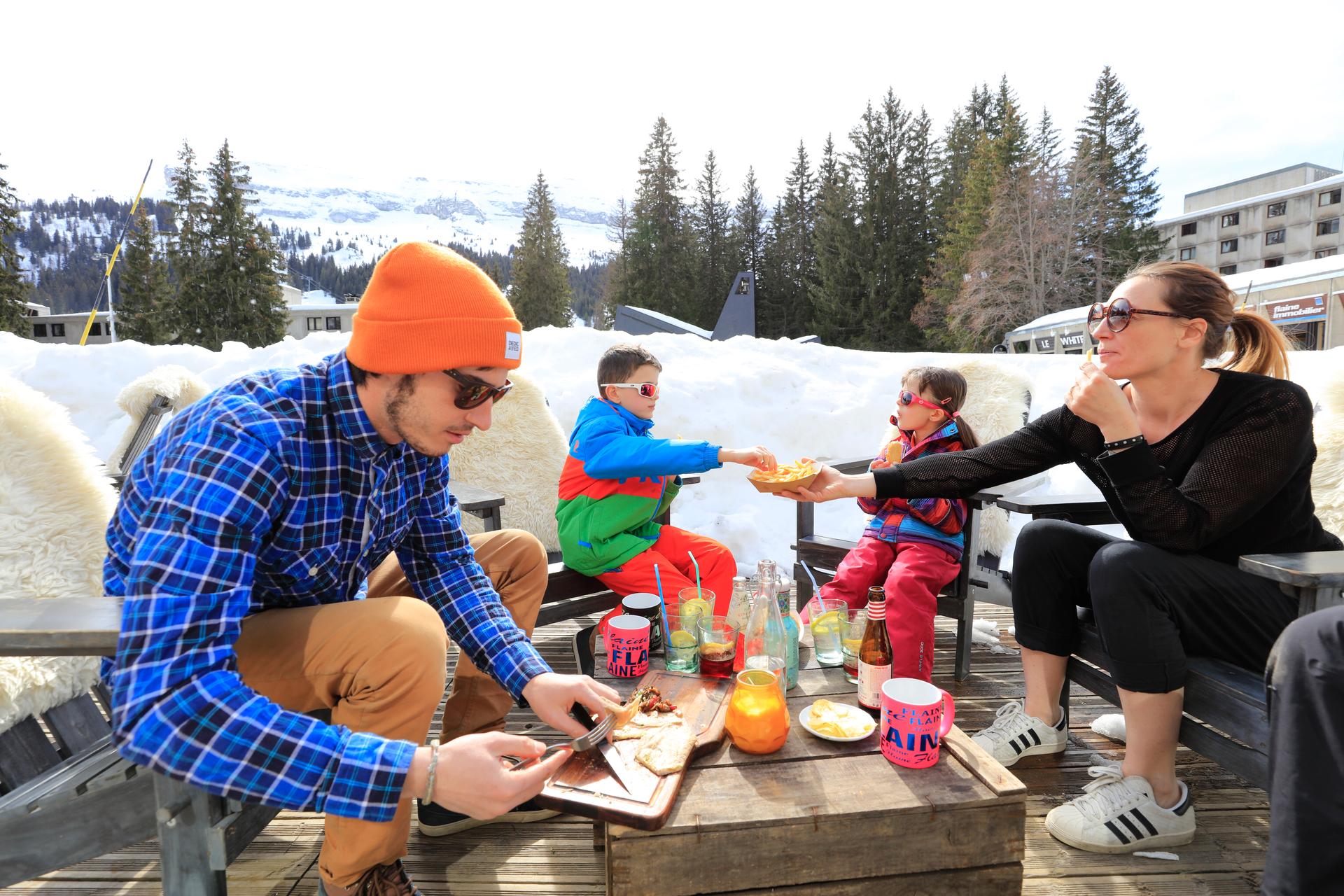 Family enjoying lunch at Flaine ski resort after skiing